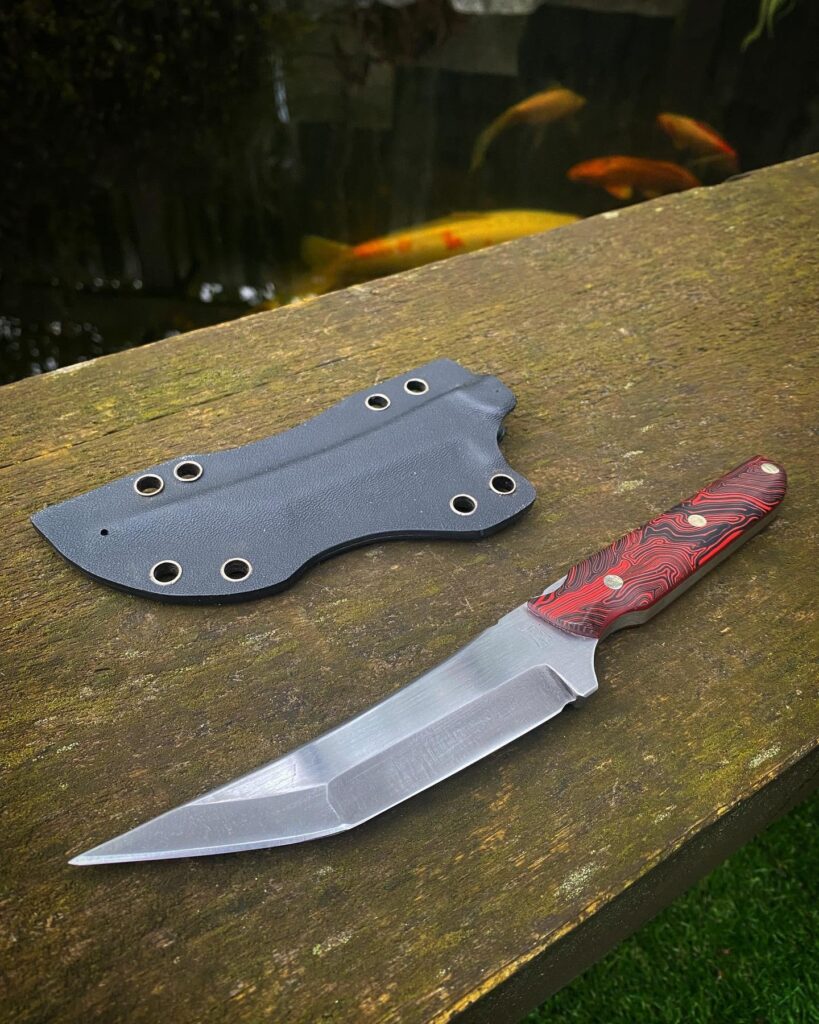 Got this Shinobi finished up today. 80crv2, 2 tone finish with acid washed bevels and hand sanded flats, red and black micarta scales, stainless silver pins and burgundy liners finished with a Kydex sheath. This version was fun to make!