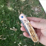 Bri folder with Mammoth ivory and Mokume bolsters that I made from 13 quarters each. The blade is mosaic Damascus. Ti frame is anodized blue and the inside engine jeweled. Floating back spacer is also Damascus. The OAL is 9in open and 5 1/8 in closed.