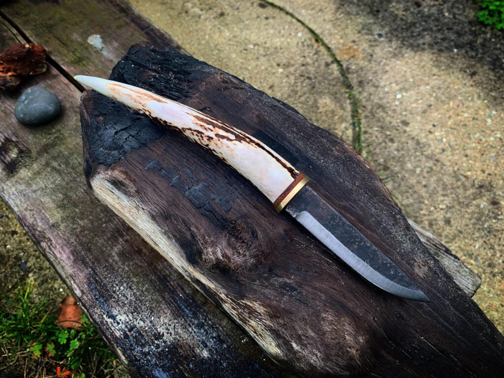 A small Puukko made by me with a handforged blade by Tilo Knuth, brass, leather and an antler tip.