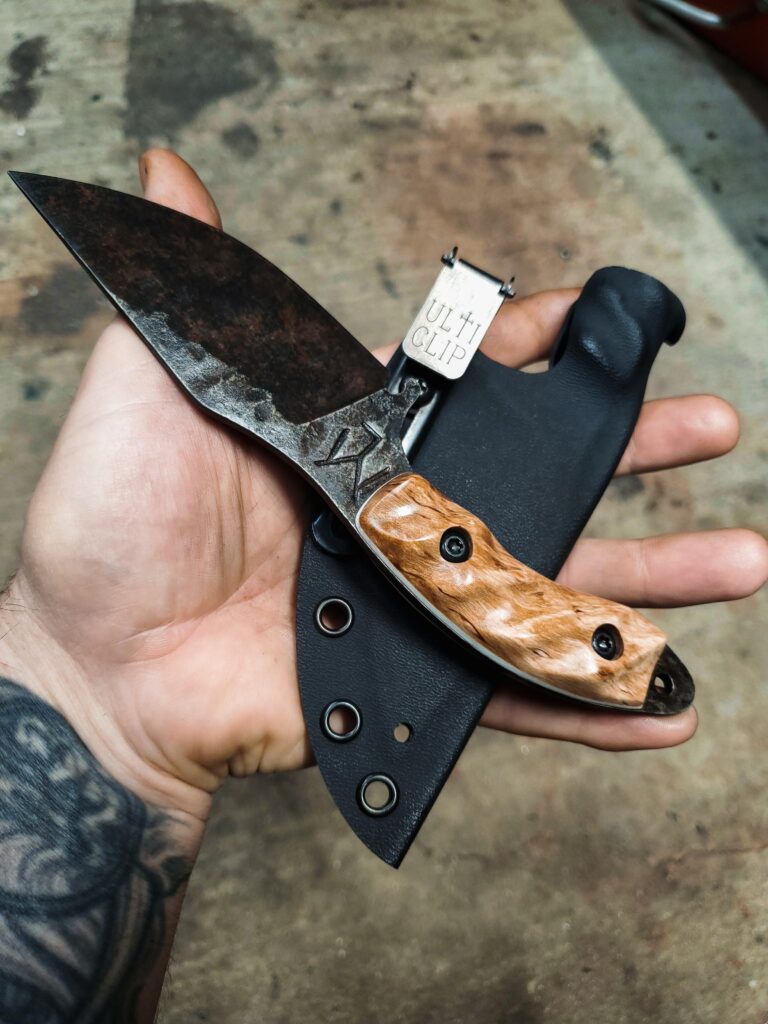 80crv2 Skinner, Apocalyptic finish, with karelian birch from and white G10 liners.