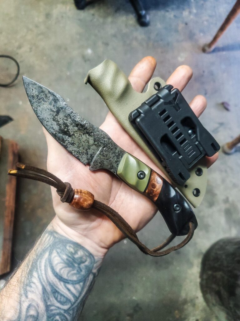 80crv2 with redwood lace burl split and G10 with Granite finish, and Curly redwood bead.