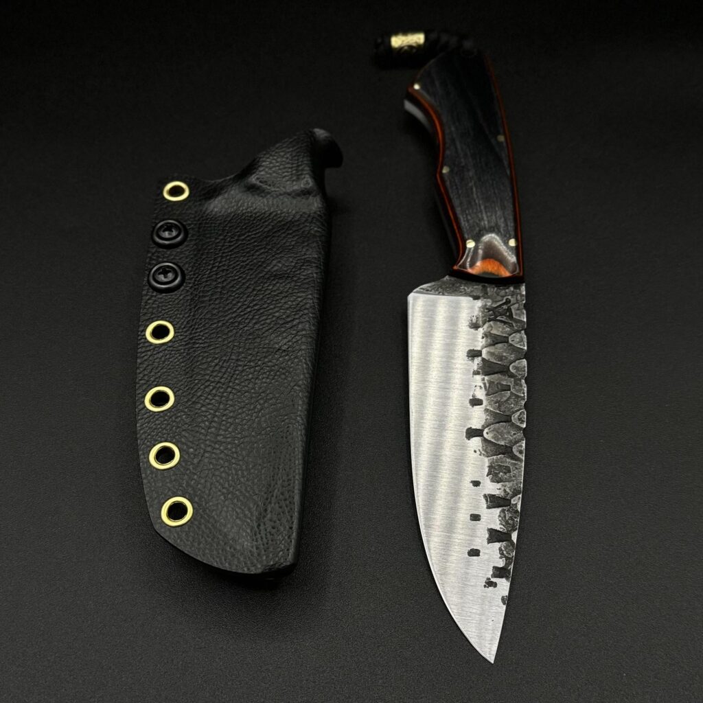 Forged dragon scale drop point finished up and paired with a dymalux handle and brass pins. Sheathed in raptor skin Kydex and a combat loop. Available