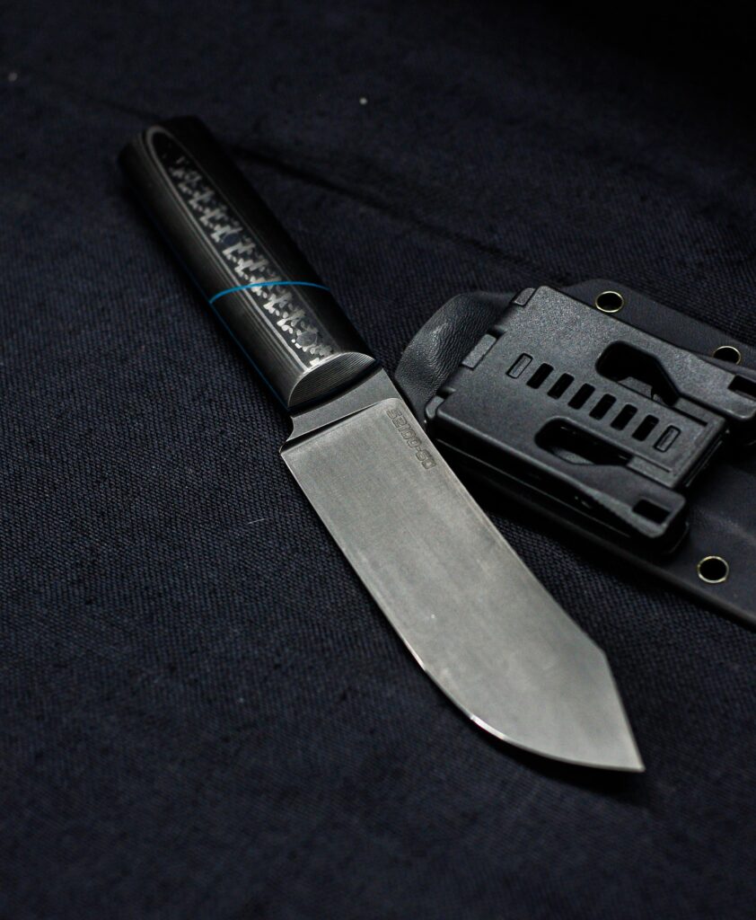 #2 of 3 Nessmuk styled blades I'm currently making. This one is 52100 at 60HRC with a carbon handle. 11.15" OAL, 5.85" blade length. What do you think?