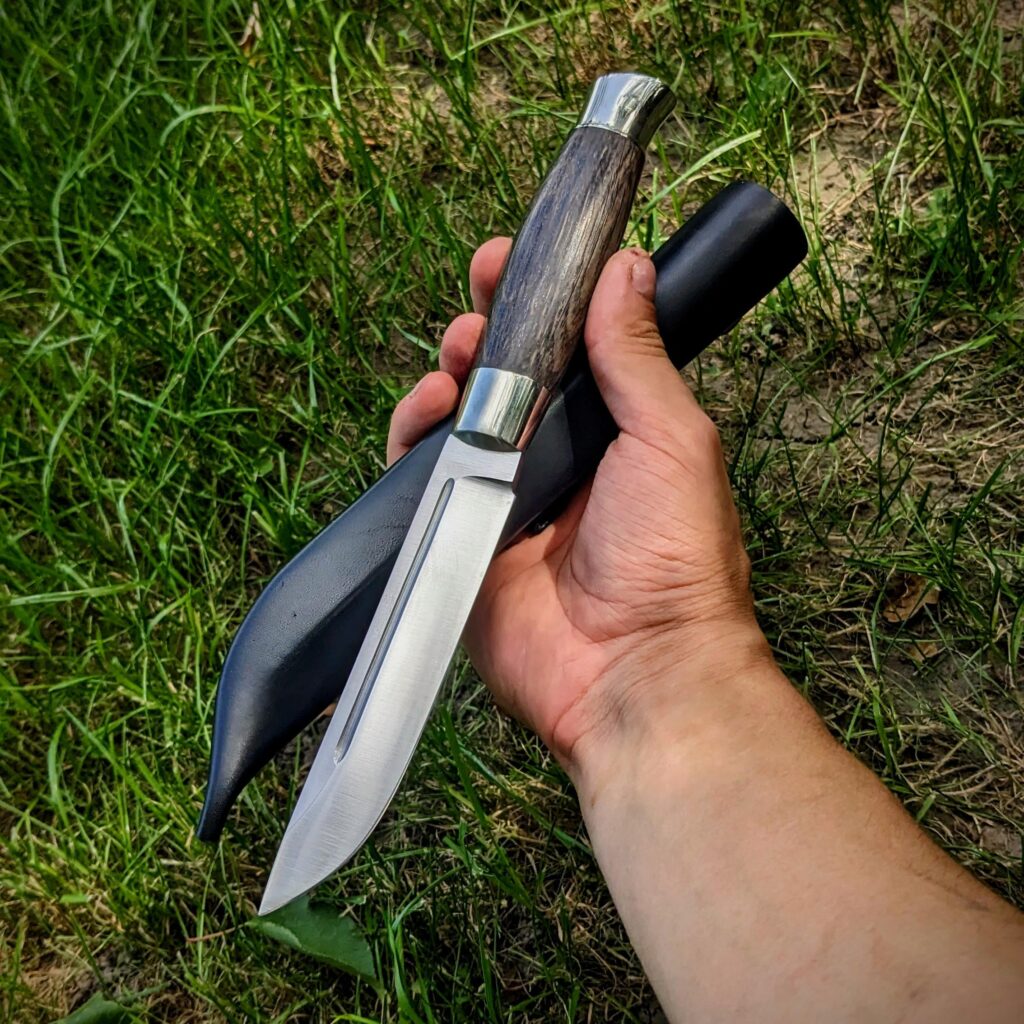 Finished sheath for this Puukko. M390 steel, 61 hrc. Stabilized Bog oak and nickel silver. I love how it turned out!