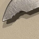 Found this 307 Buck in my dad’s shop.  Is this shape intentional, or is it a chip? It just seems shaped too pleasantly to be a chip. Maybe it’s from someone trying to open a bottle with it?