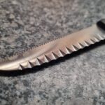 What is the purpose of these V-shaped indents that form a zigzag on the spine of the blade?