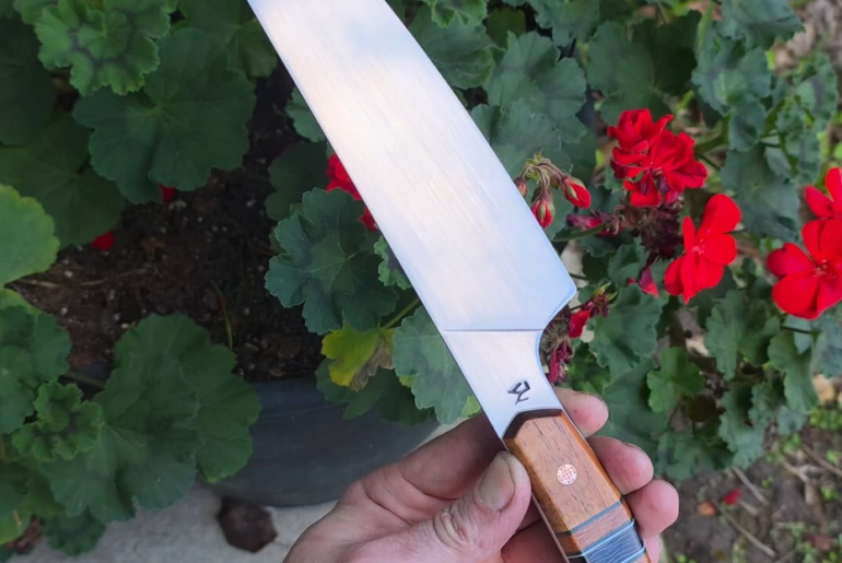 AEB-L Stainless Chef with Curly Koa and Maple Burl. The Maple burl was a cut off from the Forged In Fire continental Calvery Sabre I made years ago and its made its way into this one lol. Carbon fiber and Micarta split with white G10 liners 🤙