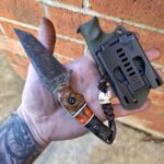 1084 with Apocalyptic with finish, handles made up of Quilted Maple 🍁 and carbon fiber. Split is G10 and dyed Zebra bone with white G10 liners. Leather Lanyard and the EDC bead is made from a Deer Molar. Very unique piece🤙