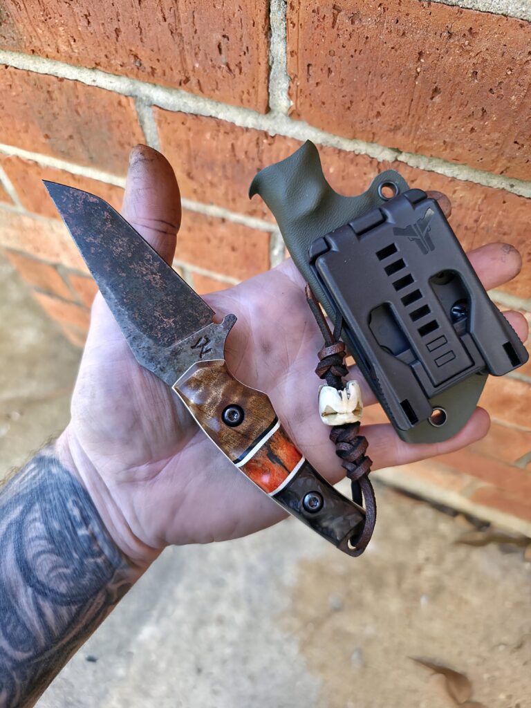 1084 with Apocalyptic with finish, handles made up of Quilted Maple 🍁 and carbon fiber. Split is G10 and dyed Zebra bone with white G10 liners. Leather Lanyard and the EDC bead is made from a Deer Molar. Very unique piece🤙