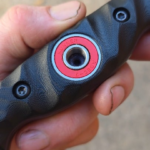 80crv2, Apocalyptic finish, Bow Drill Bushcraft knife, Sandblasted Black G10 with Royal purple liners. Stainless bow drill divot bearing.