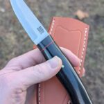 NKD BRK Forest scandi in magnacut with black linen micarta and a red spacer.