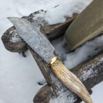 400 layers with brass and moose antler. I like big bowies and i cannot lie.