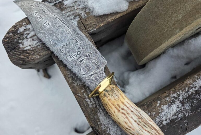 400 layers with brass and moose antler. I like big bowies and i cannot lie.