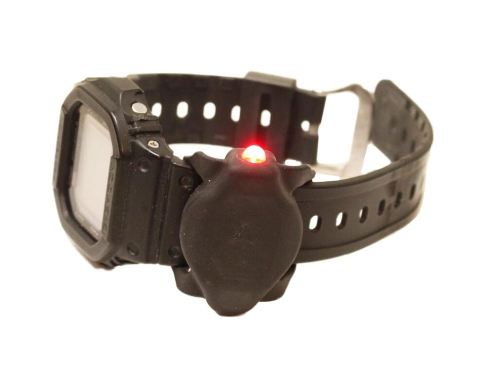 Wristwatch band mounted LED flashlight