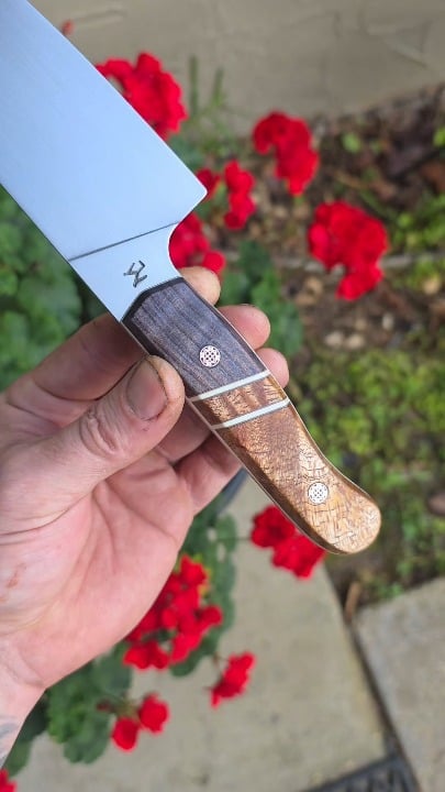 7 inch AEB-L Chef fly around. Old Growth dyed Red Wood and Quilted Maple. Ivory G10 liners.