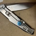 Favorite silver color-titanium/stainless scaled flipper knife? Pics? Looking for a few extra besides these I got. JW not a fan of the Pyrite or Leek. Love my P108 (smooth flip) but want higher end blade steel.