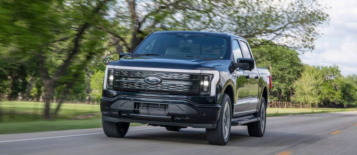Ford F-150 Lightning Platinum electric pickup truck driving on a public road.