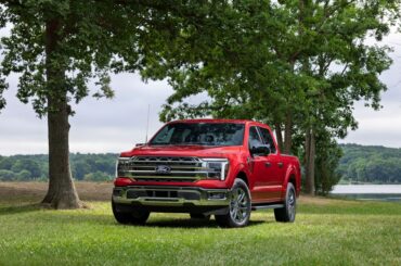 The 2027 Ford F-150 Lariat in red seen from a front quarter angle