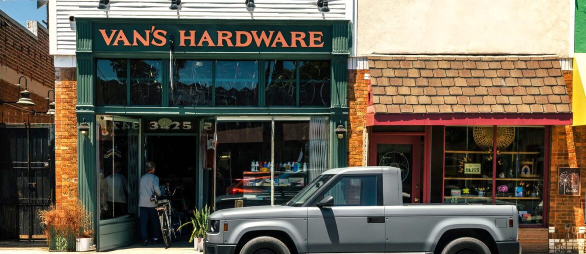 A gray pickup truck parked in front of Van's Hardware store on a sunny day.
