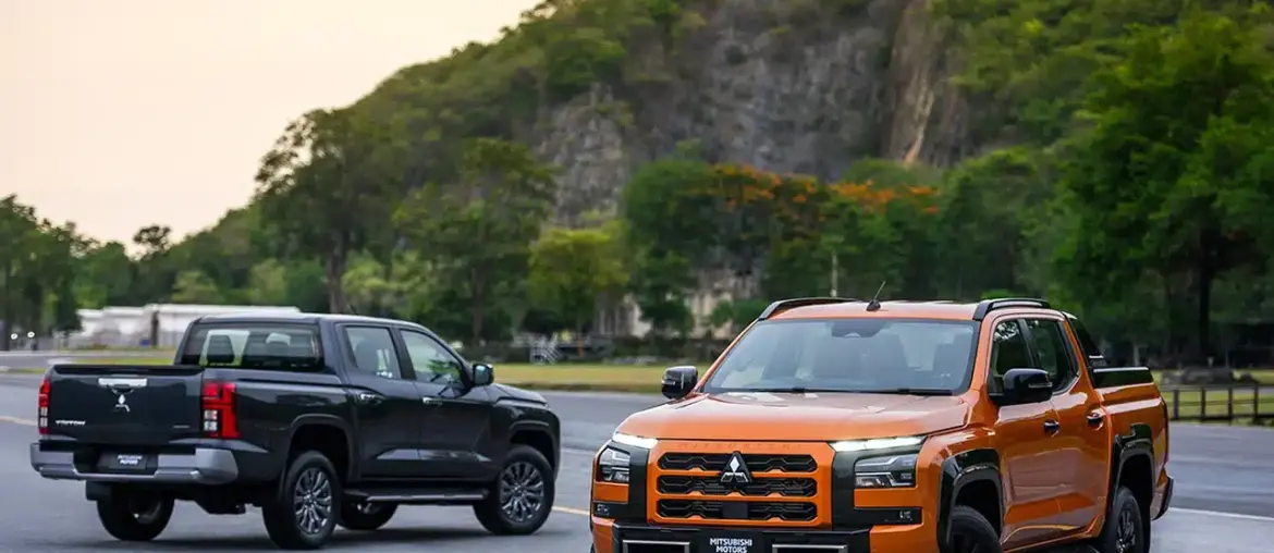 Two Mitsubishi Triton pickups, orange front view and black rear view