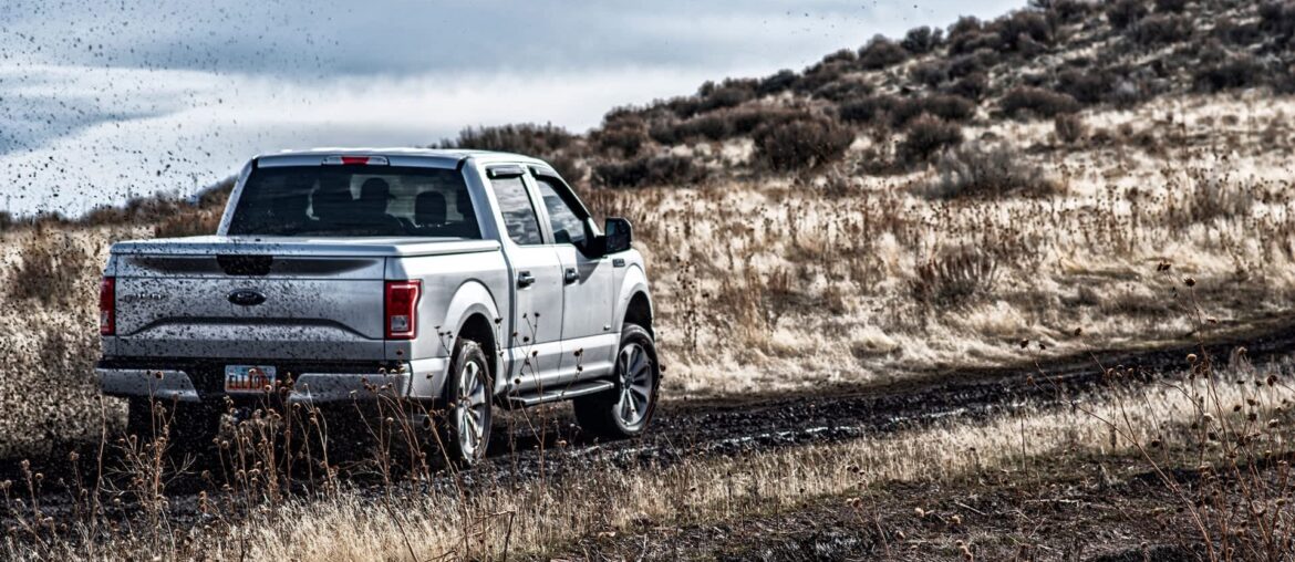 A pickup truck navigating a muddy path.