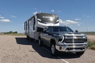 Silver Chevrolet Silverado 3500 HD Duramax towing a Cameo fifth-wheel camper