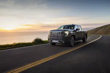 GMC Sierra 1500 Denali Ultimate driving along a coastal road