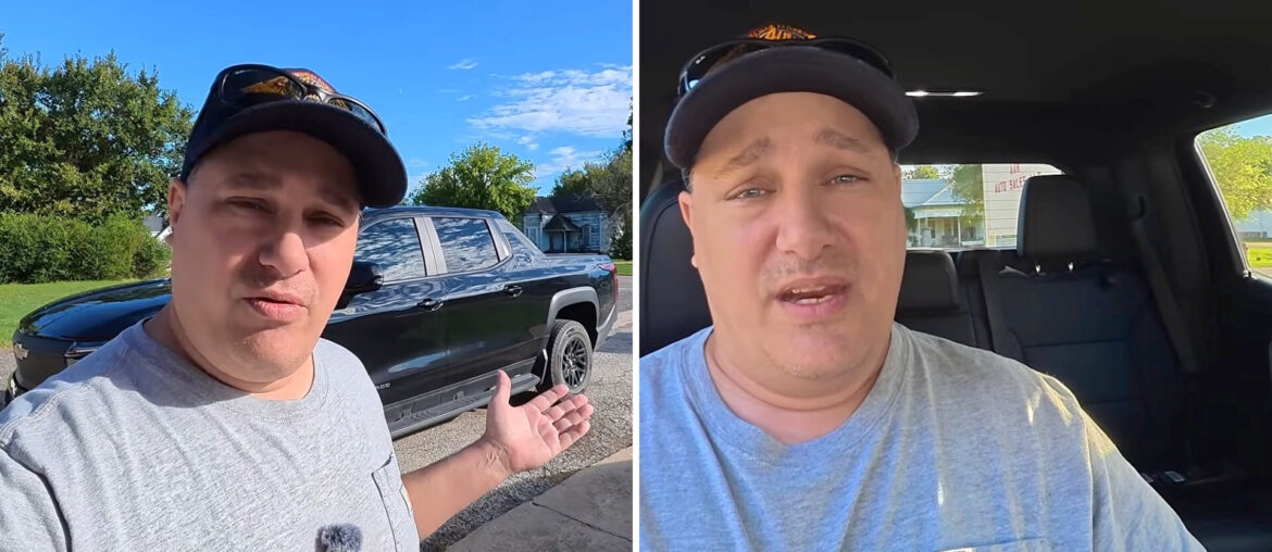 A person stands outside next to a black truck and also appears inside the truck, speaking to the camera.