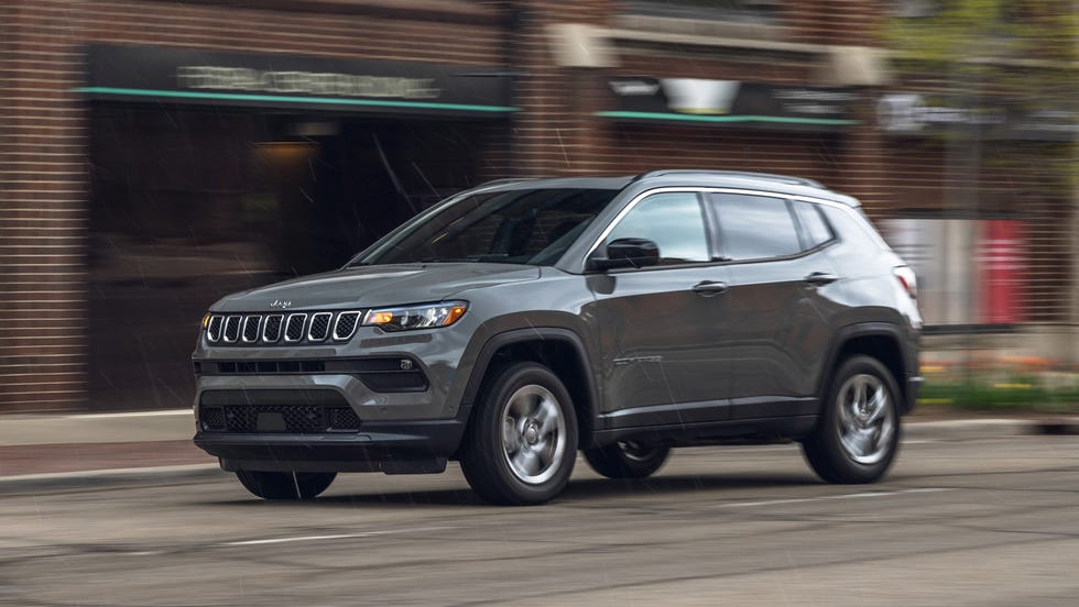 front three quarter view of gray suv driving on city street.
