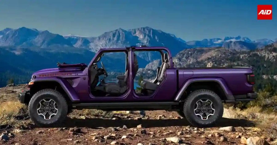 Jeep Gladiator pickup truck side profile with removable doors and roof, rugged off-road tyres and purple bodywork against a mountain backdrop